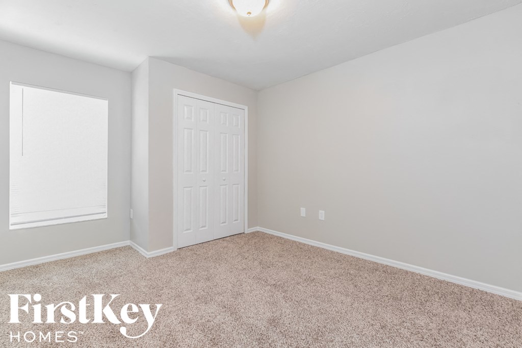 a bedroom with a white door and a carpeted floor