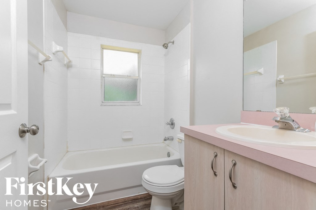 a white bathroom with a sink toilet and bath tub