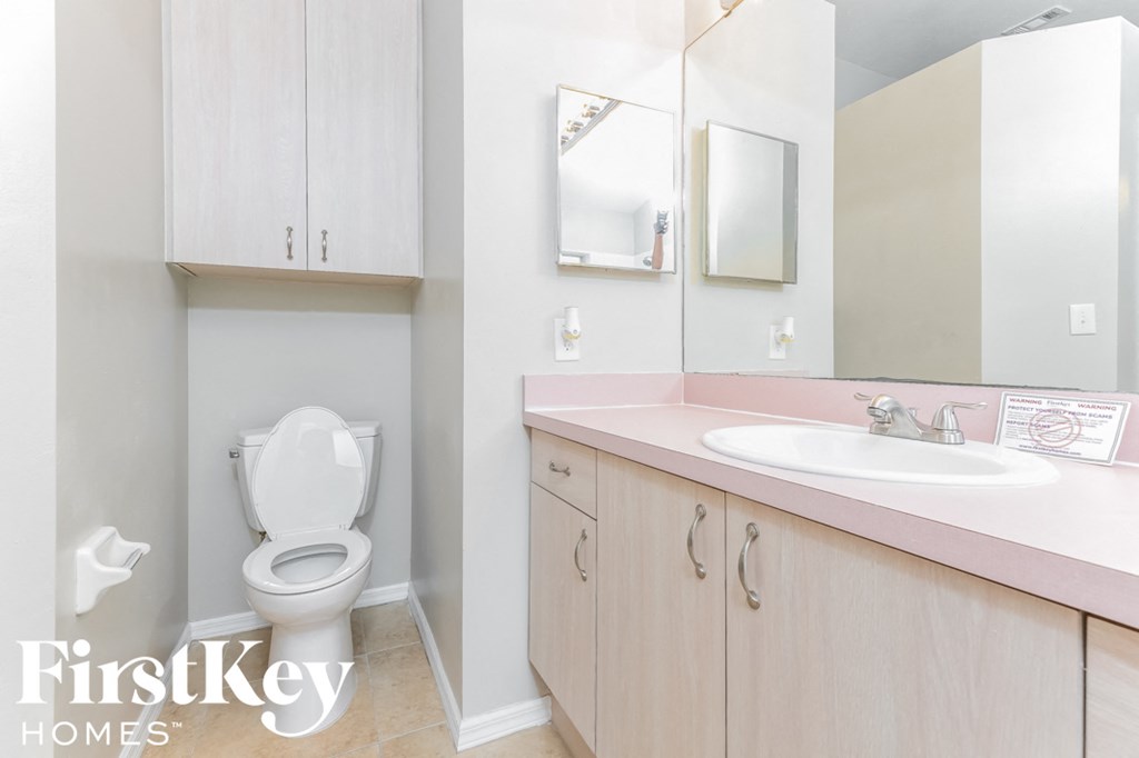 a bathroom with a toilet and a sink and a mirror