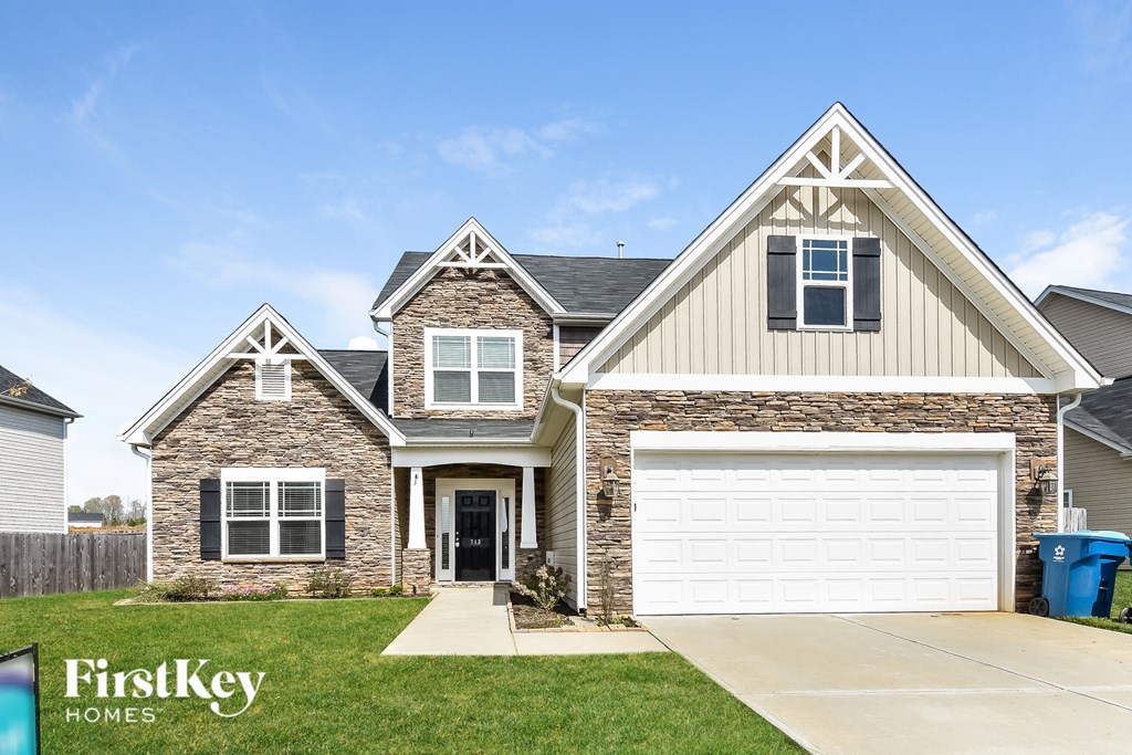 A two-story house with a garage is showcased in the image.