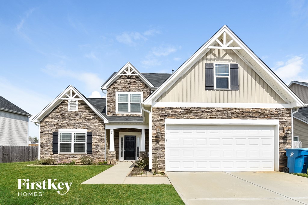 A house with a garage and a stone wall.