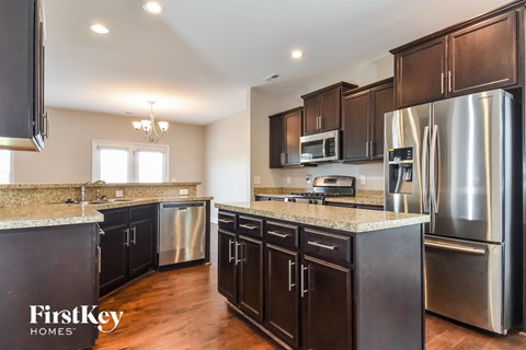 A kitchen with dark wood cabinets and stainless steel appliances.