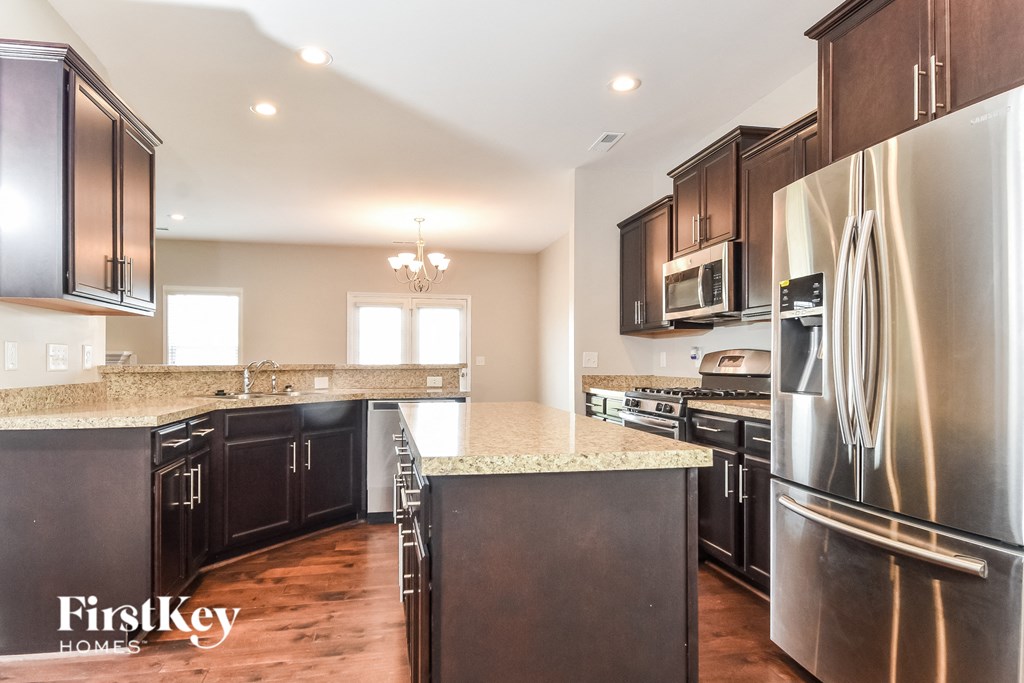 A kitchen with dark wood cabinets and a granite countertop.