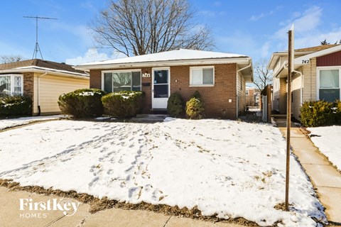 a brick house with a yard covered in snow