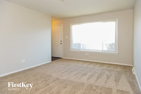 an empty living room with carpet and a large window