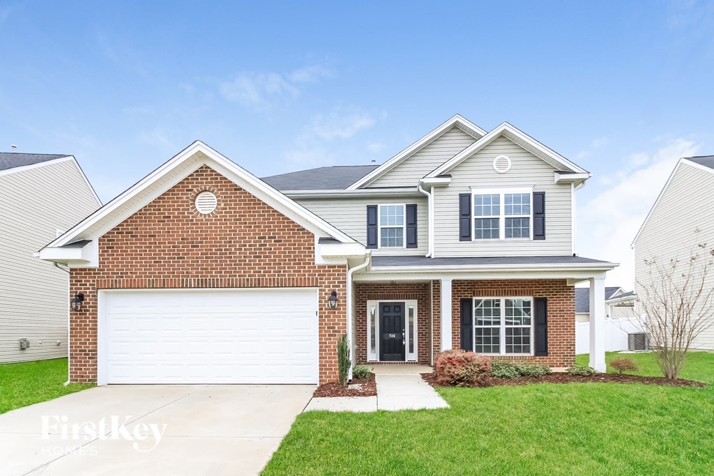 A brick house with a white garage door and a black door.