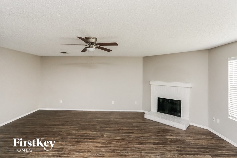 a living room with a fireplace and a ceiling fan