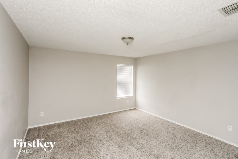 an empty room with carpet and a light on the ceiling