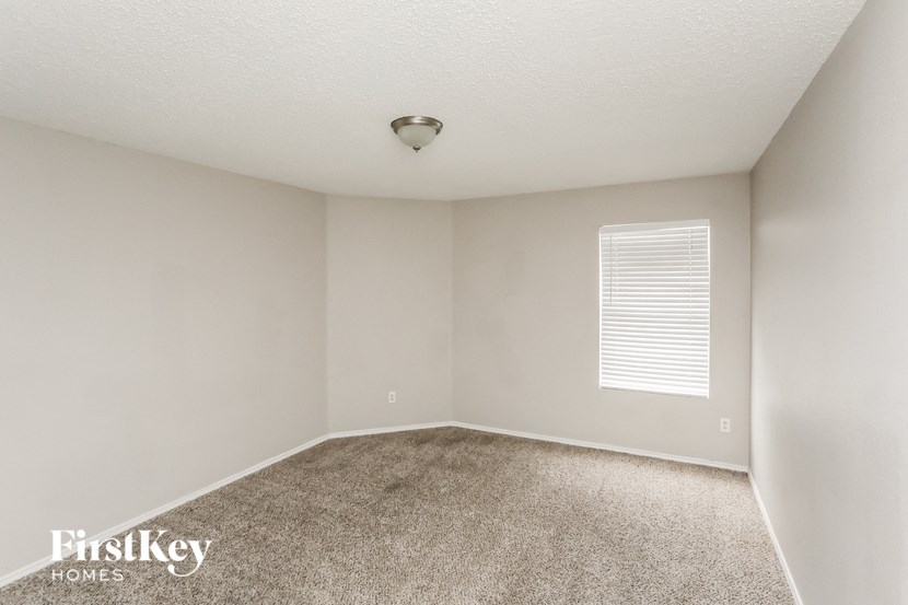 an empty room with carpet and a window