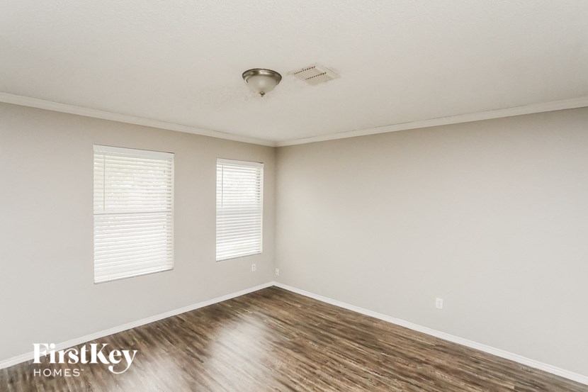 the spacious living room with hardwood flooring and white walls