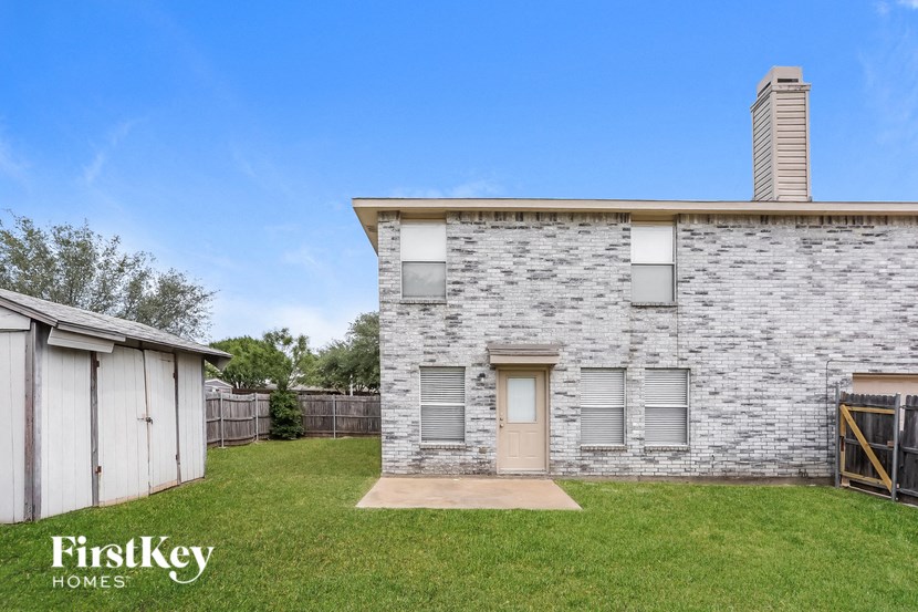 a white brick house with a yard and a garage