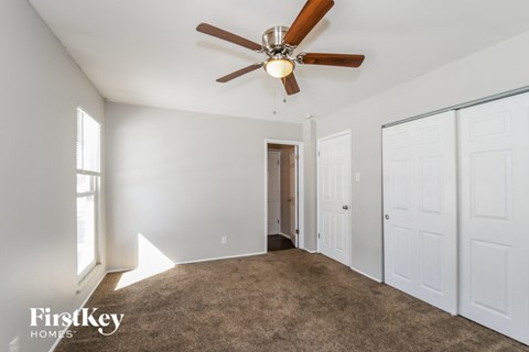 a living room with carpet and a ceiling fan