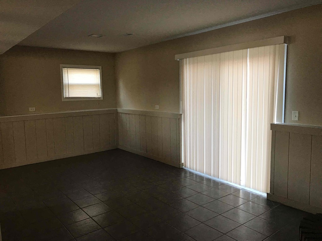 A room with a window and a tiled floor.
