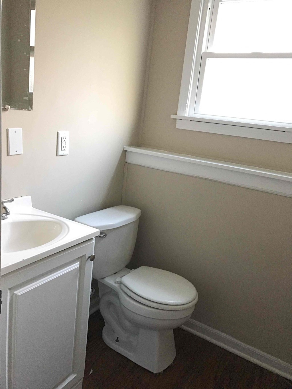 A white toilet sits next to a sink in a bathroom.
