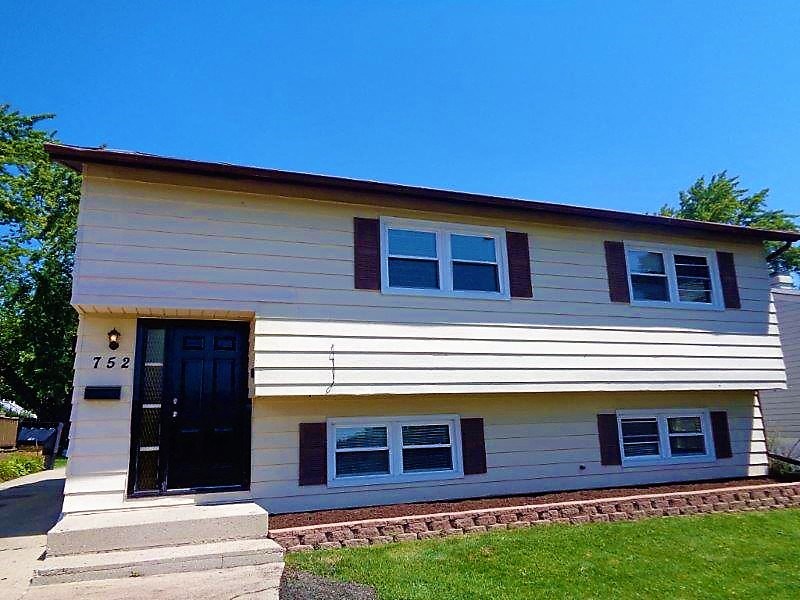 A two-story house with a black front door and a small porch.