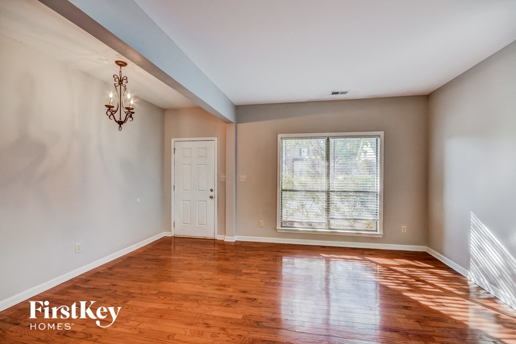 an empty living room with wood floors and a window