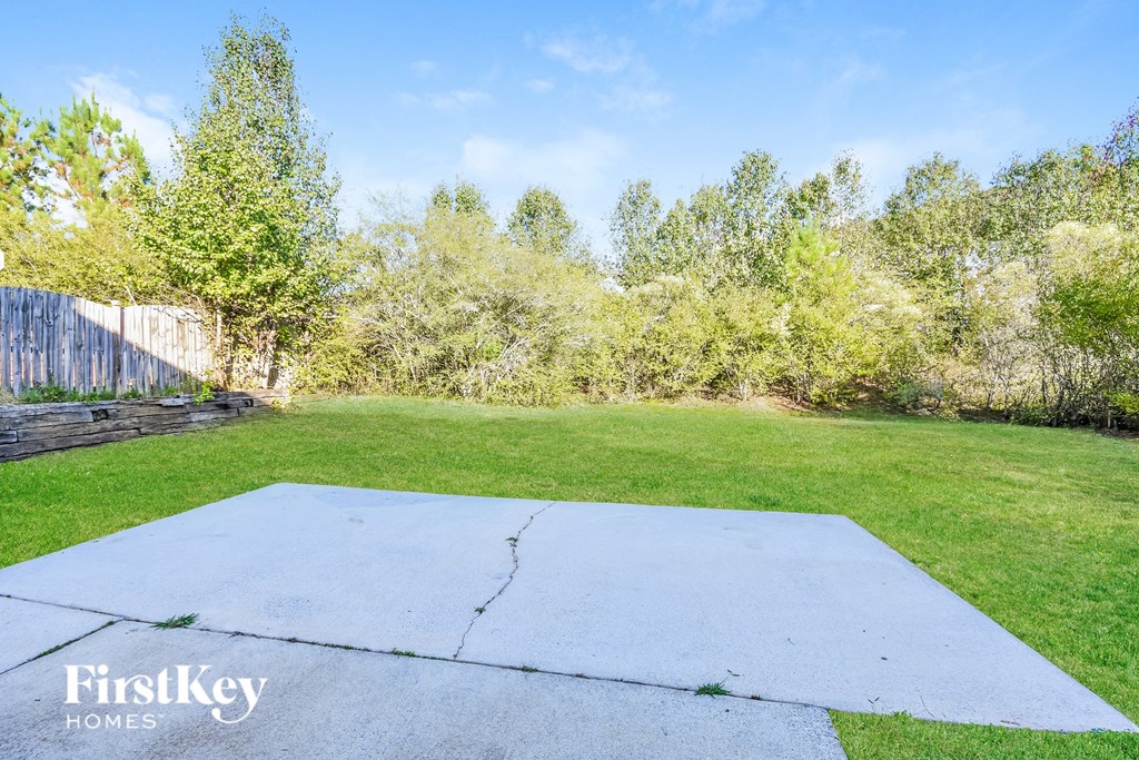 the backyard has a large concrete slab in the middle of the grass