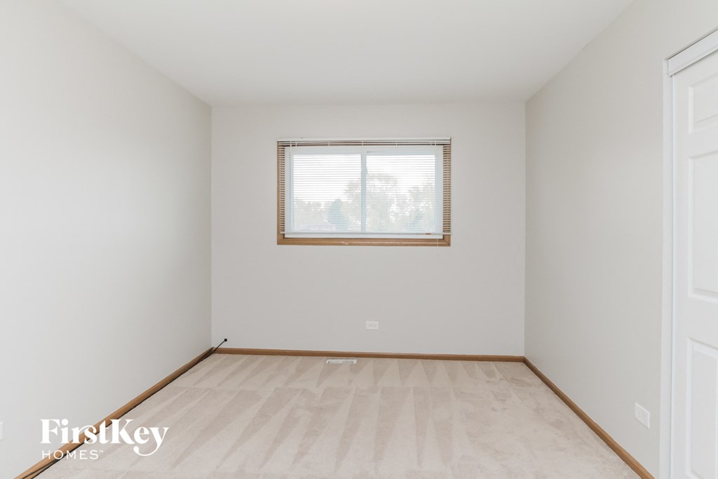 A room with a window and wooden flooring.