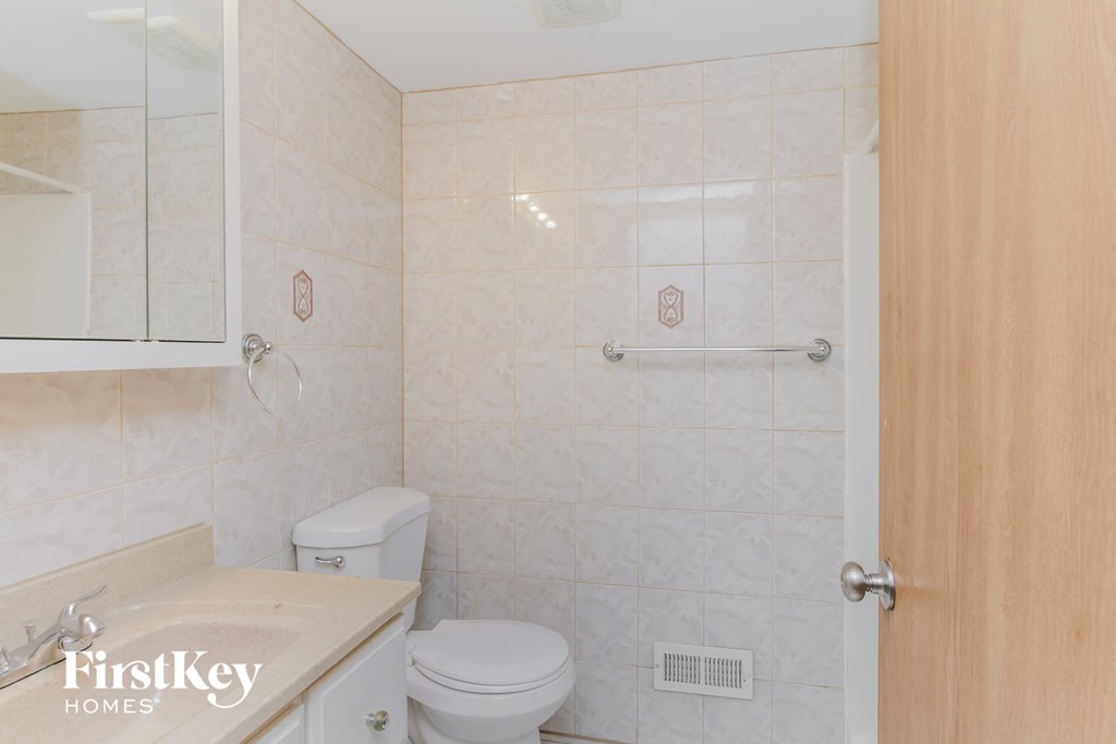 A bathroom with a toilet, sink, and shower.