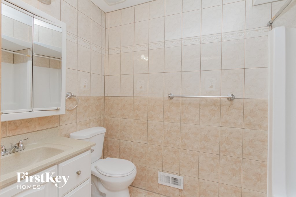 A bathroom with a toilet, sink, and a shower.