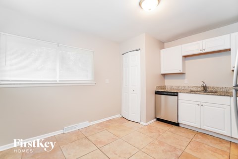 A kitchen with a sink, dishwasher, and cabinets.
