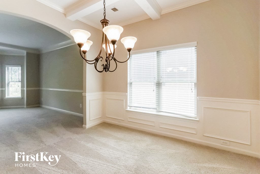 a dining room with a large window and a chandelier