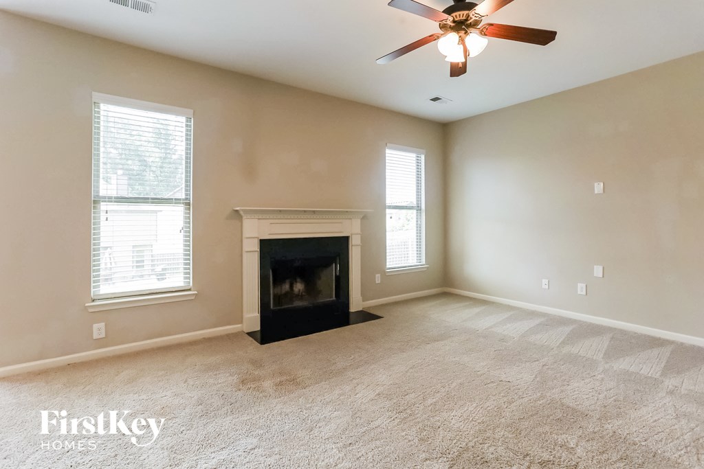 a living room with a fireplace and a ceiling fan