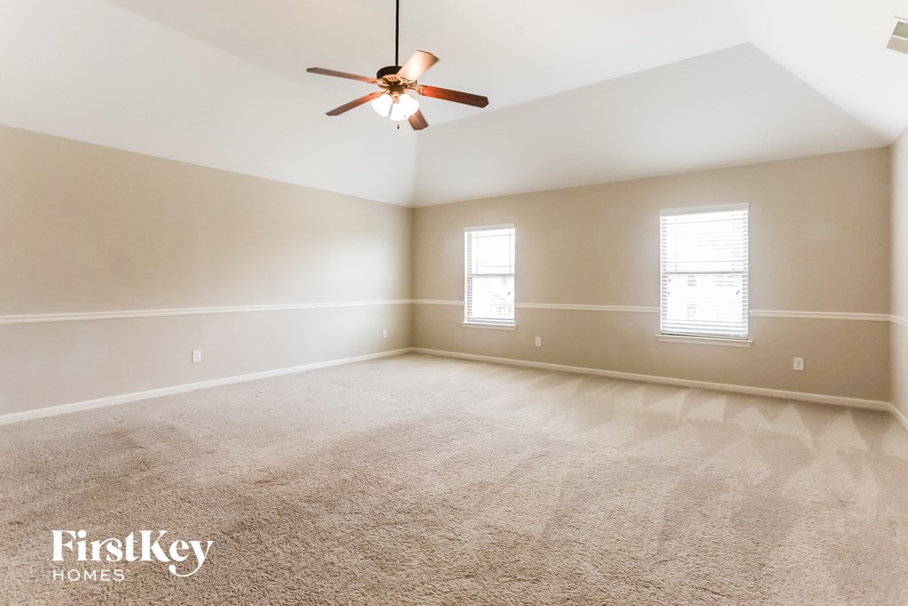 a bedroom with a ceiling fan and a carpeted floor