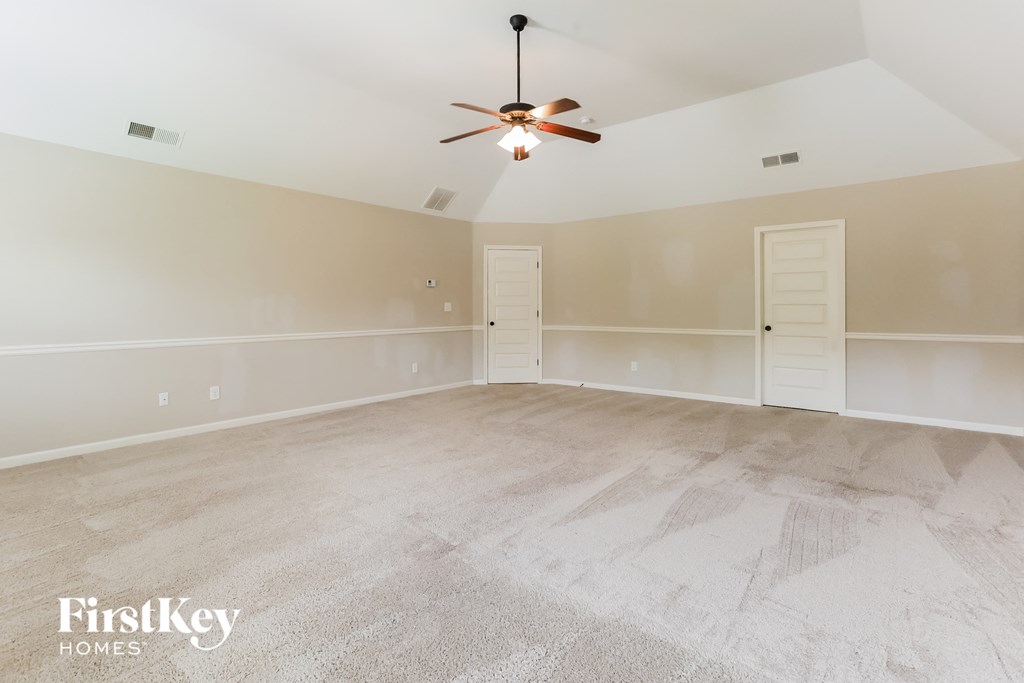 the living room of an empty home with a ceiling fan