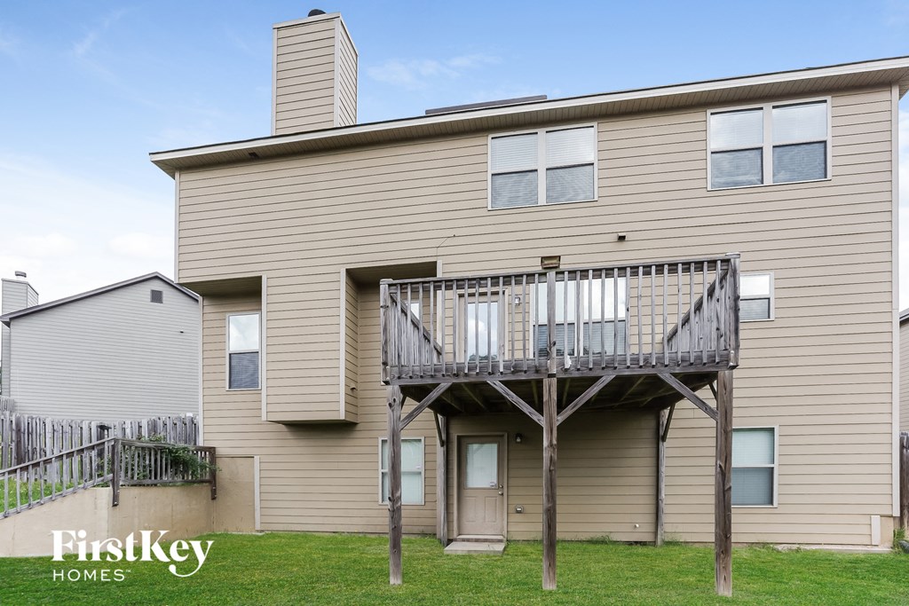 the back of a house with a deck and a balcony