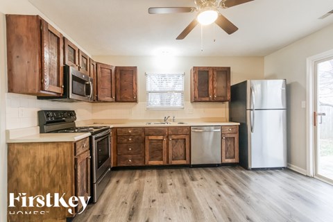 A kitchen with wooden cabinets and a stainless steel refrigerator.