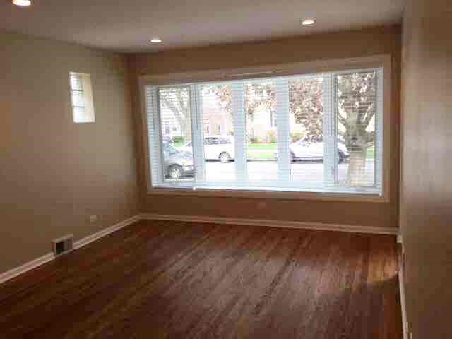 a living room with a large window and wooden floors