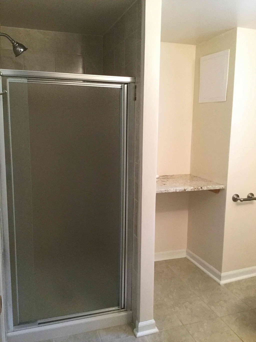 a small bathroom with a shower and a shelf