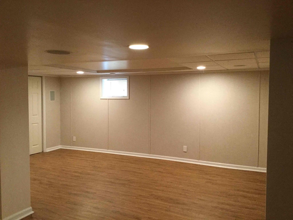 an empty living room with a wood floor and a window