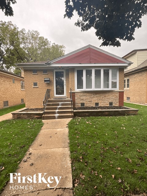 a small brick house with a sidewalk in front of it