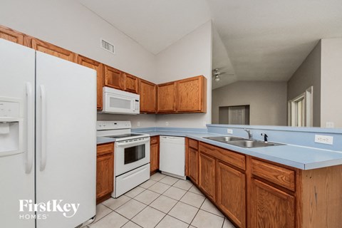 a kitchen with white appliances and wooden cabinets
