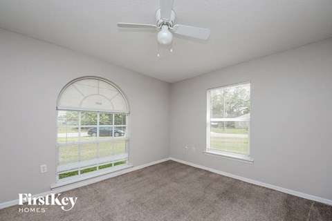 a living room with a ceiling fan and a window