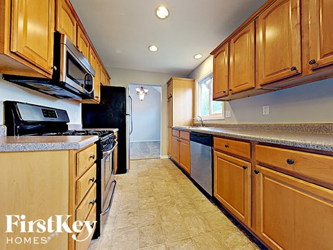 A kitchen with wooden cabinets and a refrigerator.
