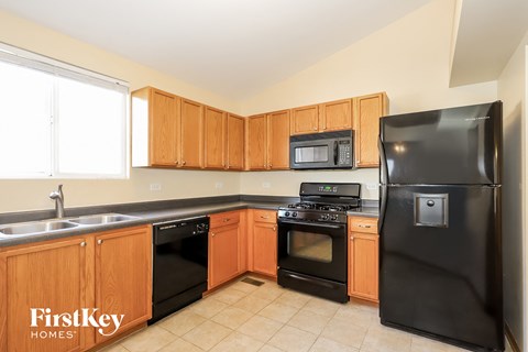 A kitchen with wooden cabinets and black appliances.
