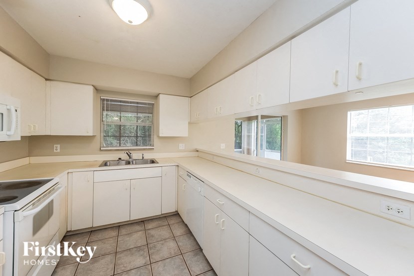 a white kitchen with white cabinets and white appliances