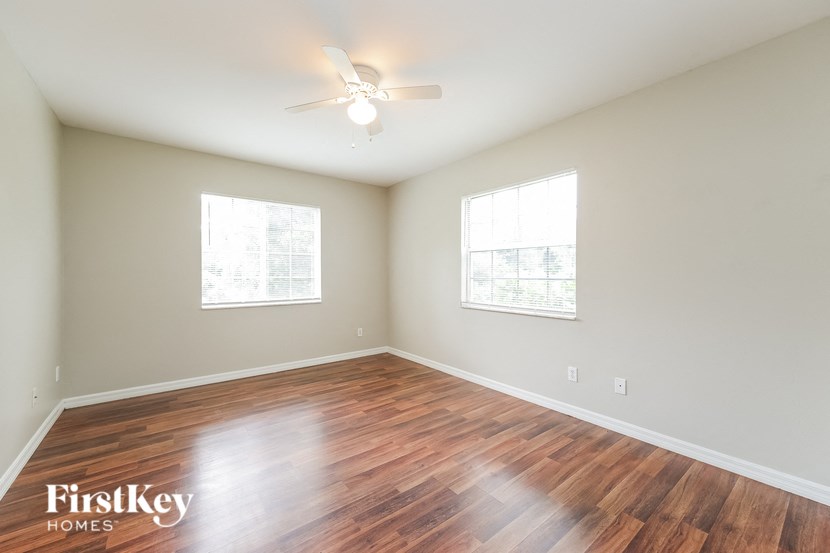 a living room with a hard wood floor and a ceiling fan