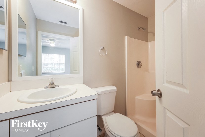 a bathroom with a sink toilet and a mirror