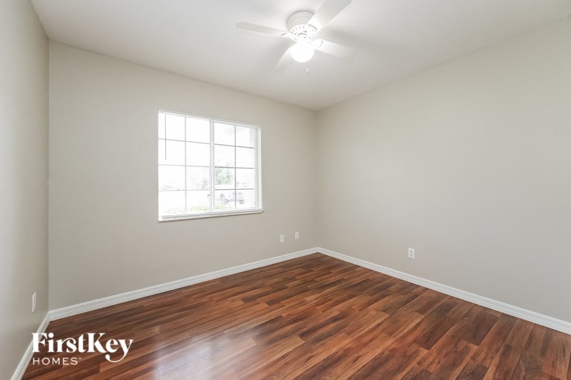 a living room with a hard wood floor and a ceiling fan