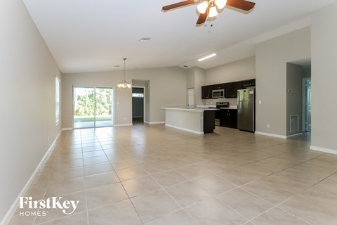 an empty kitchen and living room with a large tile floor