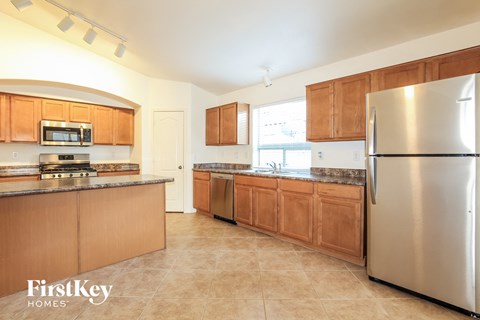 A kitchen with wooden cabinets and a stainless steel refrigerator.