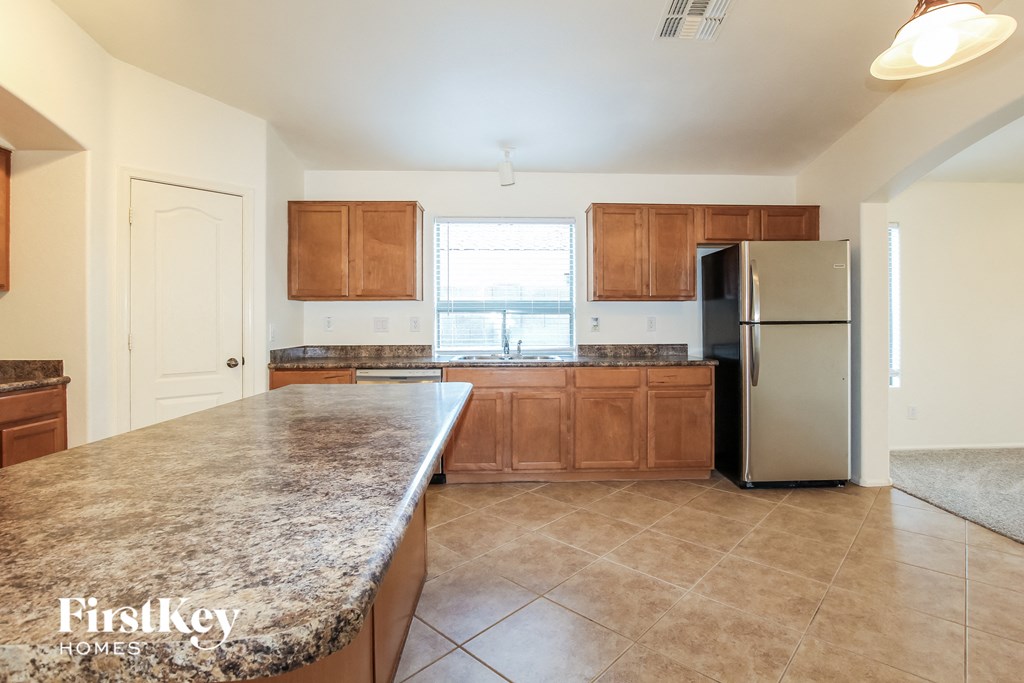A kitchen with granite countertops and wooden cabinets.