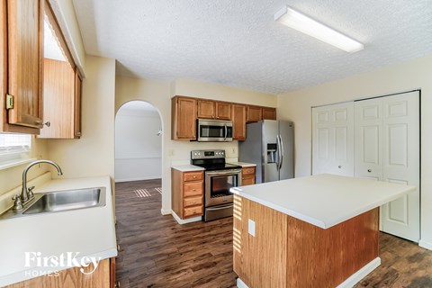 A kitchen with wooden cabinets and a white island.