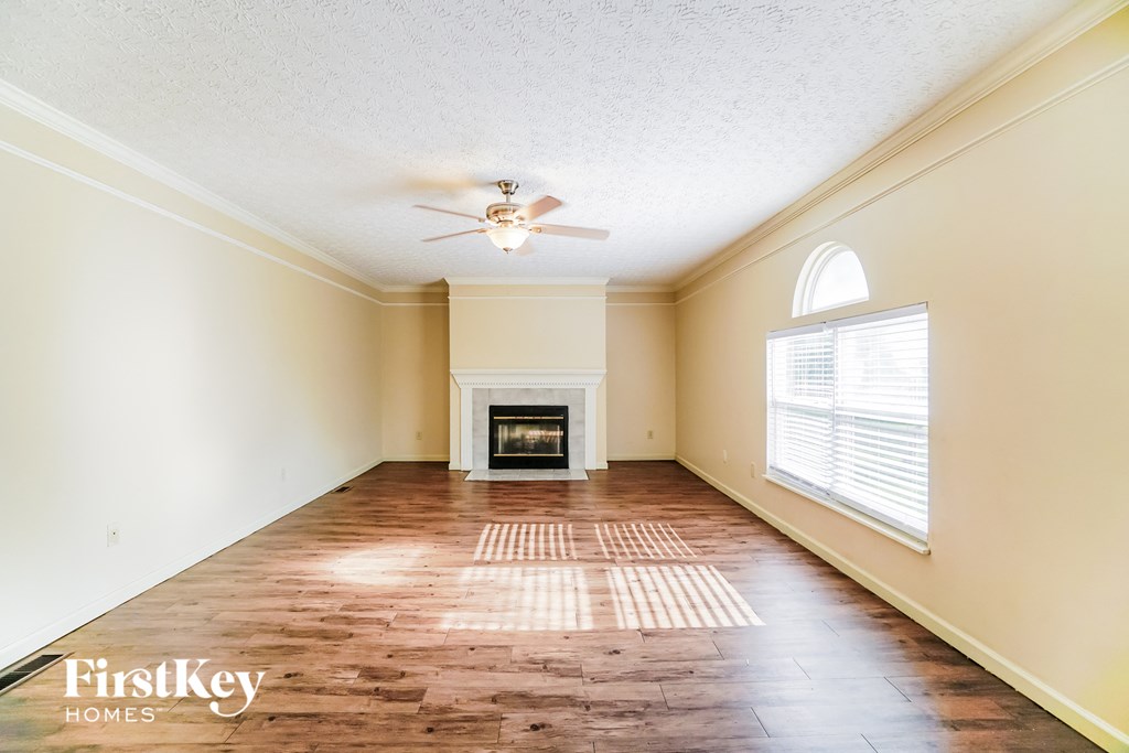 A room with a fireplace and a ceiling fan.