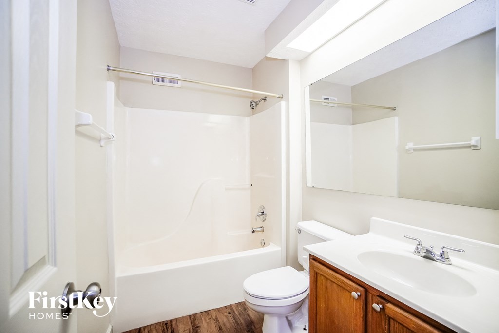 A white bathroom with a toilet, sink, and bathtub.