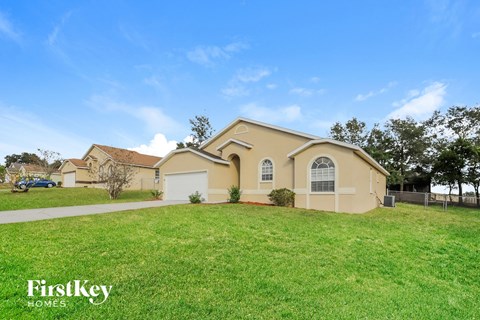 a beige house with a lawn in front of it